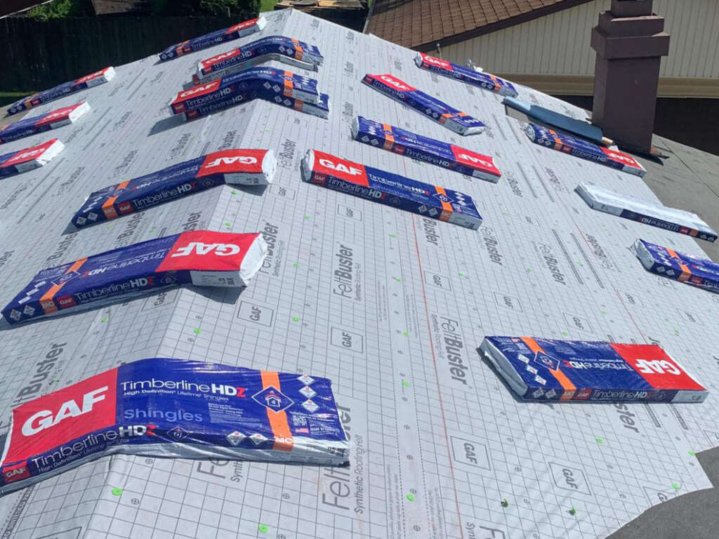 GAF Timberline HD shingles packages scattered on roof underlayment during residential roofing installation