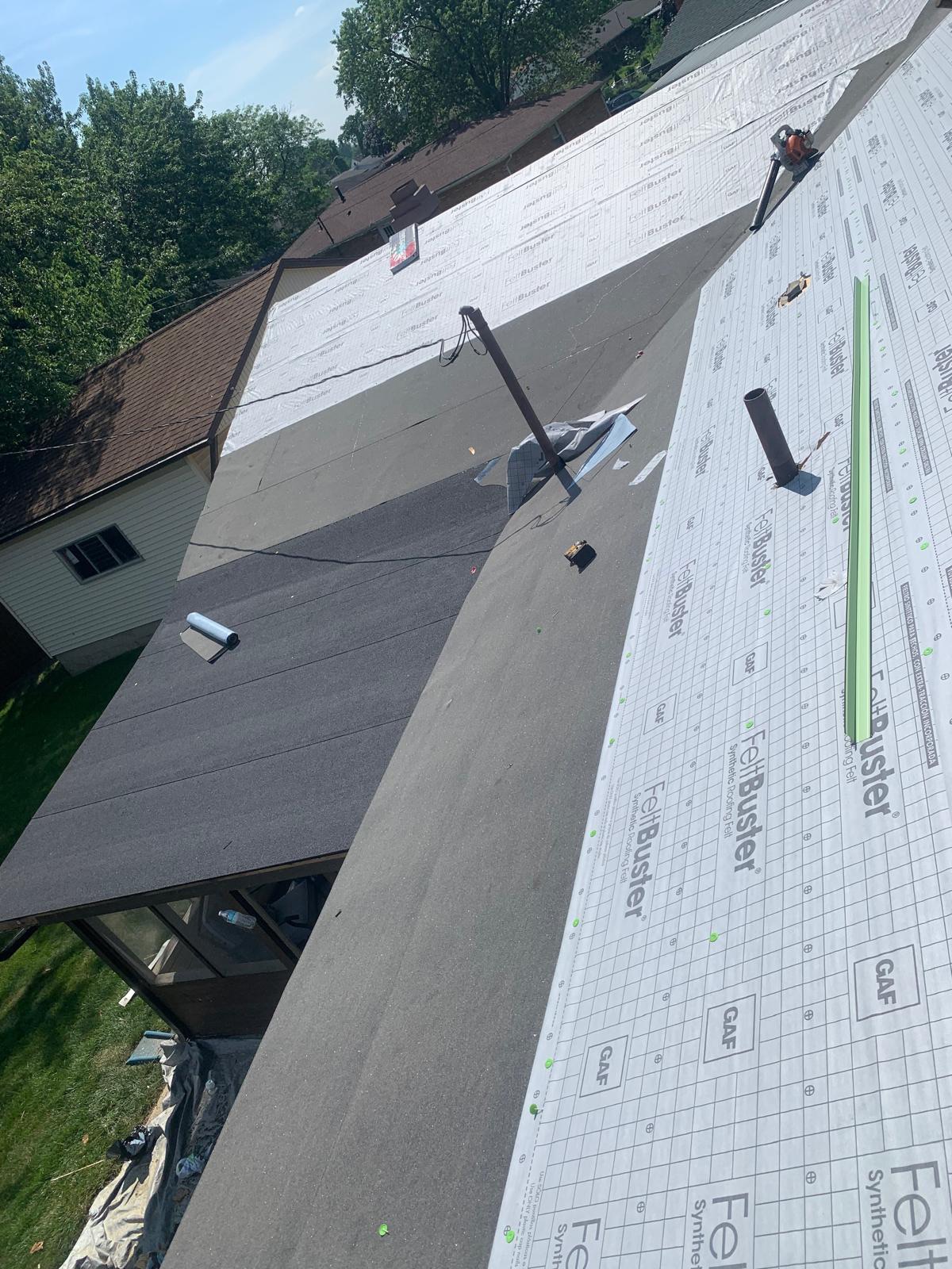 Aerial view of roof replacement project showing GAF FeltBuster synthetic underlayment installation in progress